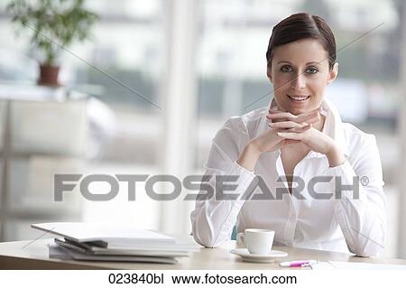 portrait of young businesswoman sitting at table View Large Photo Image Stock Image - portrait of young businesswoman sitting at table. Fotosearch