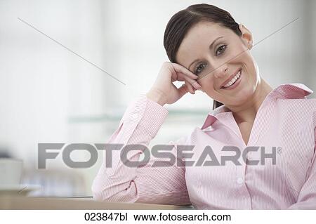 portrait of young businesswoman sitting at table View Large Photo Image Stock Image - portrait of young businesswoman sitting at table. Fotosearch