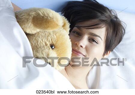 portrait of young woman lying in bed with cuddly toy View Large Photo Image Stock Image - portrait of young woman lying in bed with cuddly toy. Fotosearch