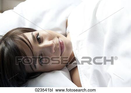 portrait of young woman lying in bed View Large Photo Image Stock Image - portrait of young woman lying in bed. Fotosearch