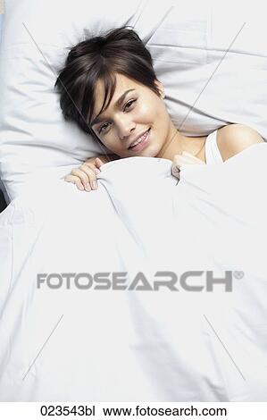 portrait of young woman lying in bed View Large Photo Image Stock Image - portrait of young woman lying in bed. Fotosearch