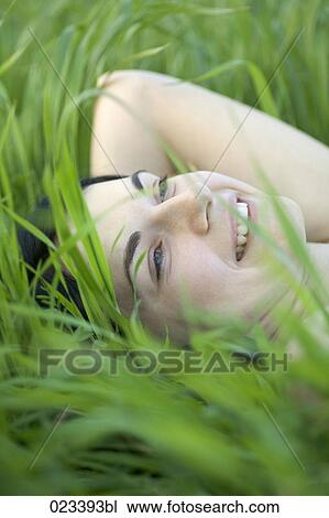 portrait of young woman lying in grass View Large Photo Image Stock Image - portrait of young woman lying in grass. Fotosearch