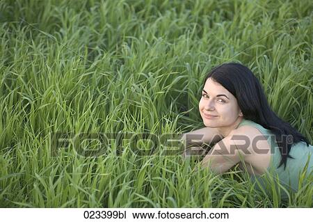 portrait of young woman lying in grass View Large Photo Image Stock Image - portrait of young woman lying in grass. Fotosearch