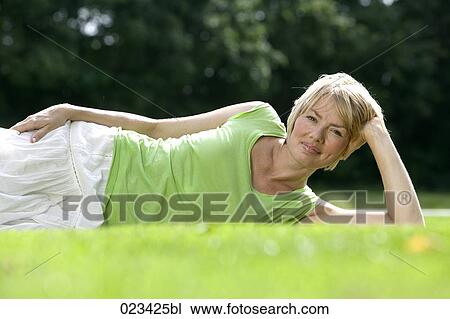 portrait of young woman lying in grass View Large Photo Image Stock Image - portrait of young woman lying in grass. Fotosearch