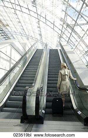 rear view of businesswoman with suitcase on escalator View Large Photo Image Stock Image - rear view of businesswoman with suitcase on escalator. Fotosearch