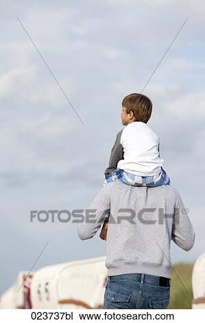 rear view of father carrying young son on his shoulders View Large Photo Image Stock Image - rear view of father carrying young son on his shoulders. Fotosearch