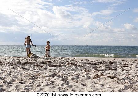 sister and brother playing in sand on the beach View Large Photo Image Stock Image - sister and brother playing in sand on the beach. Fotosearch