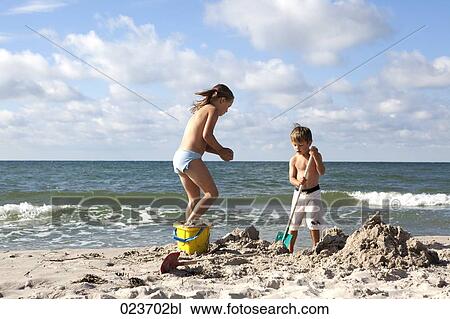 sister and brother playing in sand on the beach View Large Photo Image Stock Image - sister and brother playing in sand on the beach. Fotosearch