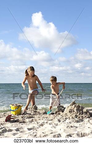 sister and brother playing in sand on the beach View Large Photo Image Stock Image - sister and brother playing in sand on the beach. Fotosearch