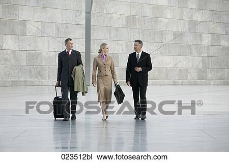 three business people walking through hall View Large Photo Image Stock Image - three business people walking through hall. Fotosearch