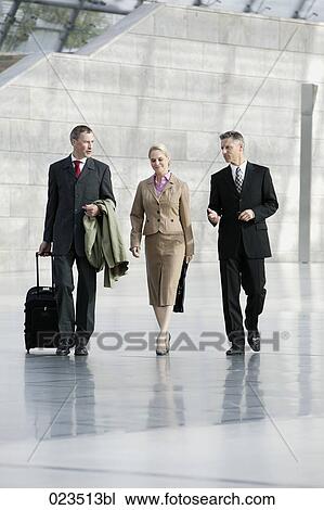 three business people walking through hall View Large Photo Image Stock Image - three business people walking through hall. Fotosearch