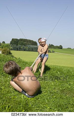 three children playing tug-of-war View Large Photo Image Stock Image - three children playing tug-of-war. Fotosearch