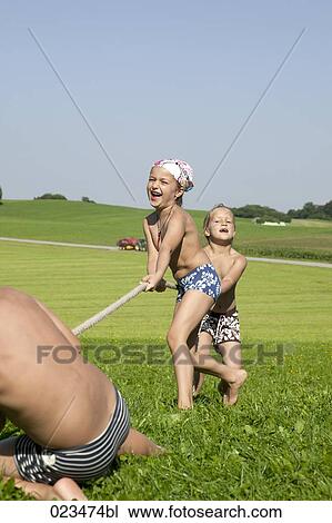 three children playing tug-of-war View Large Photo Image Stock Image - three children playing tug-of-war. Fotosearch