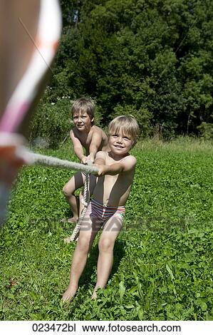 two boys playing tug-of-war View Large Photo Image Stock Image - two boys playing tug-of-war. Fotosearch