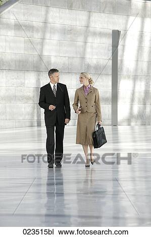two business people walking through hall View Large Photo Image Stock Image - two business people walking through hall. Fotosearch