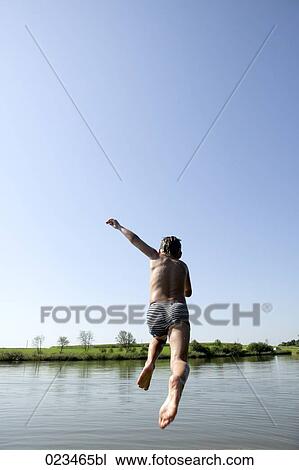 young boy jumping into lake View Large Photo Image Stock Image - young boy jumping into lake. Fotosearch