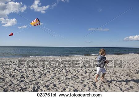 young boy playing with kite on beach View Large Photo Image Stock Image - young boy playing with kite on beach. Fotosearch