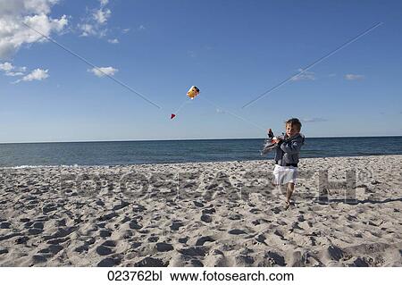 young boy playing with kite on beach View Large Photo Image Stock Image - young boy playing with kite on beach. Fotosearch