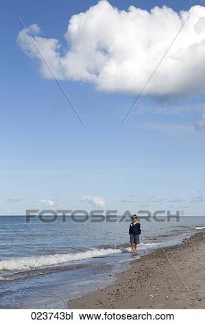 young boy standing on beach View Large Photo Image Stock Image - young boy standing on beach. Fotosearch