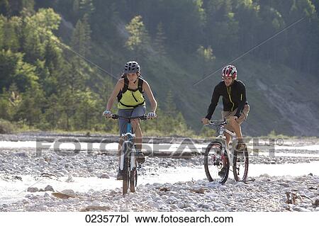 young couple cycling through nature View Large Photo Image Stock Image - young couple cycling through nature. Fotosearch