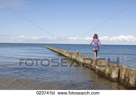 young girl walking on wooden poles at seaside View Large Photo Image Stock Image - young girl walking on wooden poles at seaside. Fotosearch