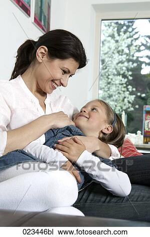 young woman and daughter having fun on sofa View Large Photo Image Stock Image - young woman and daughter having fun on sofa. Fotosearch