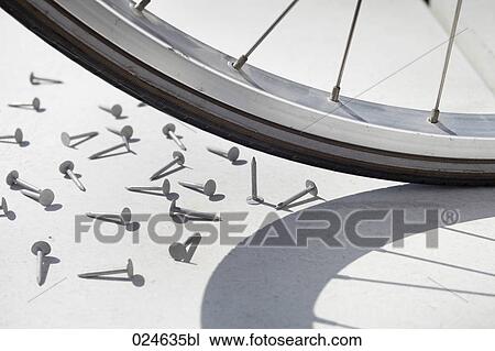 Stock Image - close-up of bicycle wheel and nail. Fotosearch