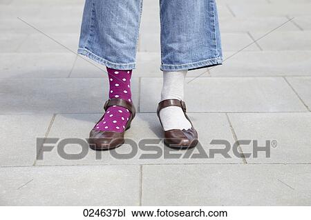 Stock Image - detail of woman wearing different socks. Fotosearch