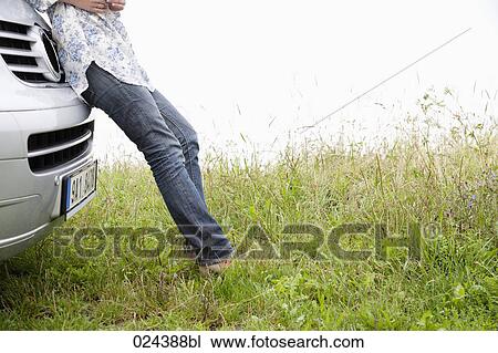 Stock Image - detail of young woman leaning against car. Fotosearch