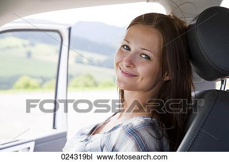 Stock Image - headshot of young woman sitting in car. Fotosearch