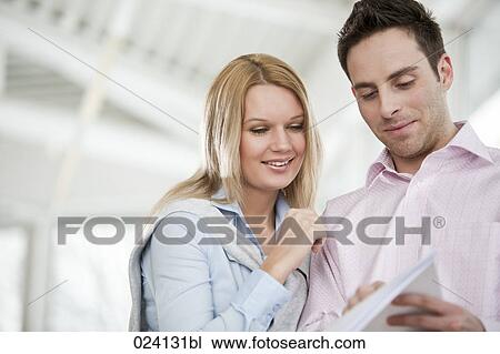 portrait of businessman and female colleague reading document View Large Photo Image Stock Image - portrait of businessman and female colleague reading document. Fotosearch