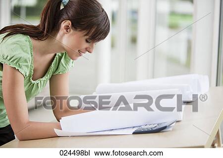 Stock Image - portrait of female architect correcting blueprint. Fotosearch