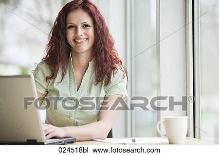 portrait of red haired businesswoman working with laptop computer View Large Photo Image Stock Image - portrait of red haired businesswoman working with laptop computer. Fotosearch