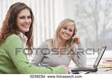 Stock Image - portrait of two young businesswomen in office. Fotosearch