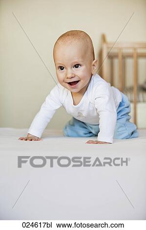 Stock Image - portrait of young baby boy crouching on floor. Fotosearch