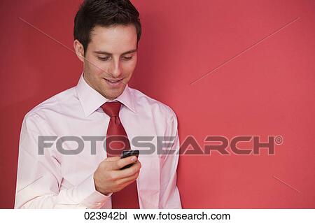 portrait of young businessman checking his mobile phone View Large Photo Image Stock Image - portrait of young businessman checking his mobile phone. Fotosearch