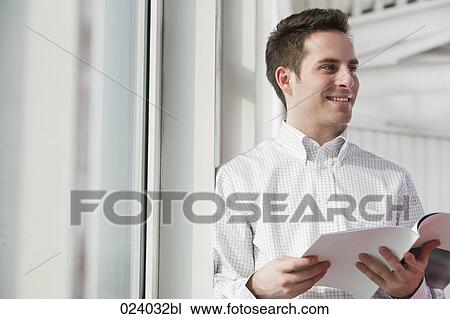 portrait of young businessman reading file View Large Photo Image Stock Image - portrait of young businessman reading file. Fotosearch