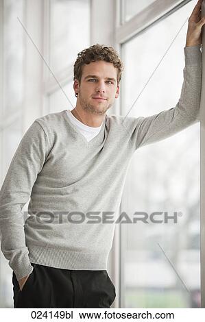 portrait of young businessman standing by a window View Large Photo Image Stock Image - portrait of young businessman standing by a window. Fotosearch