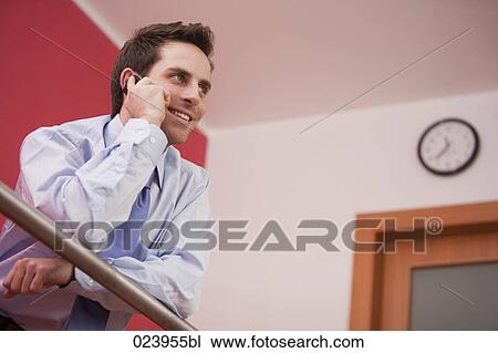 Stock Image - portrait of young businessman talking on mobile phone. Fotosearch