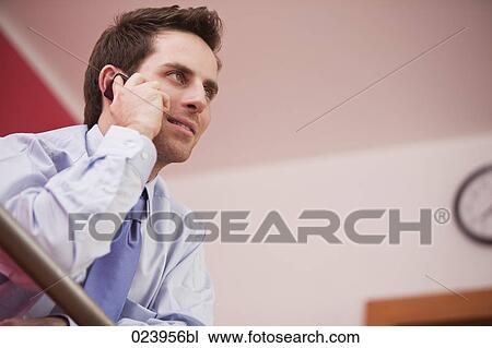 Stock Image - portrait of young businessman talking on mobile phone. Fotosearch
