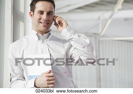 Stock Image - portrait of young businessman talking on mobile phone. Fotosearch
