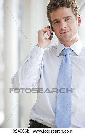 Stock Image - portrait of young businessman talking on mobile phone. Fotosearch