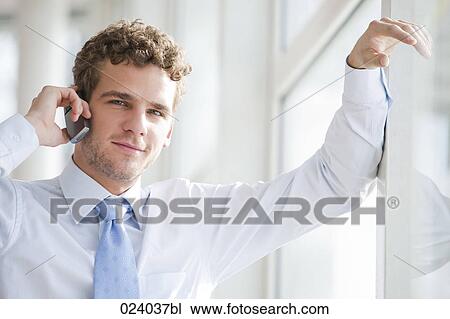 Stock Image - portrait of young businessman talking on mobile phone. Fotosearch