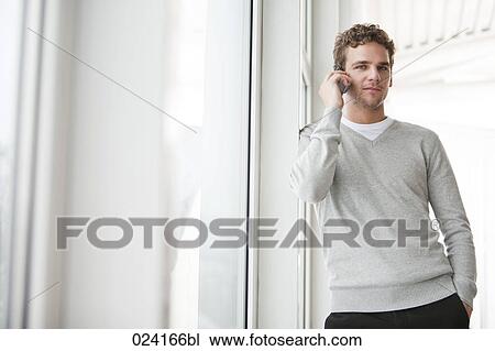 Stock Image - portrait of young businessman talking on mobile phone. Fotosearch