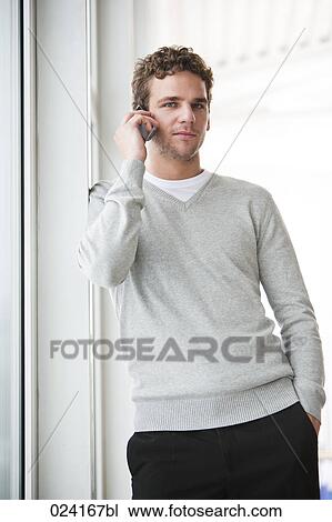 Stock Image - portrait of young businessman talking on mobile phone. Fotosearch
