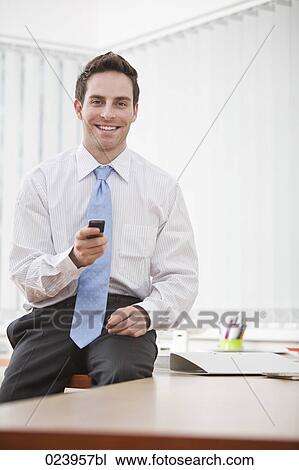 Stock Image - portrait of young businessman with mobile phone. Fotosearch