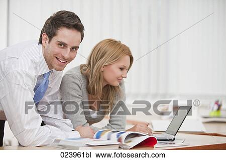 Stock Image - portrait of young businessman with female colleague. Fotosearch