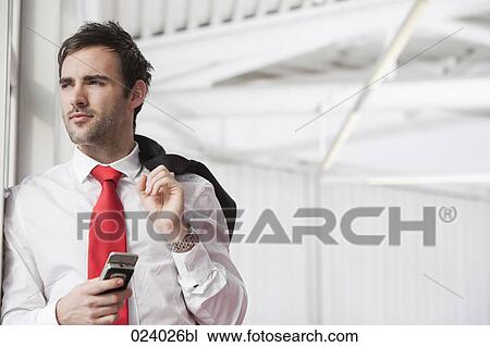 Stock Image - portrait of young businessman with mobile phone. Fotosearch