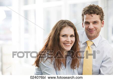 Stock Image - portrait of young businesswoman and male colleague. Fotosearch