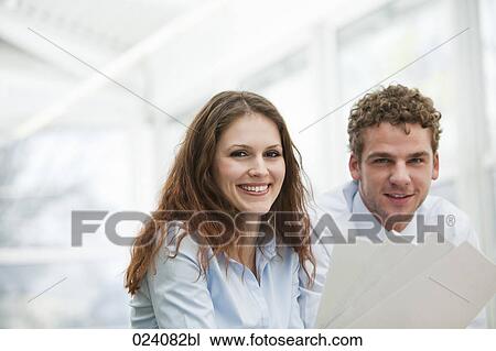 Stock Image - portrait of young businesswoman and male colleague. Fotosearch